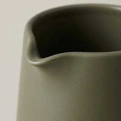 Concept close-up of the ceramic jug’s pouring lip and glaze.