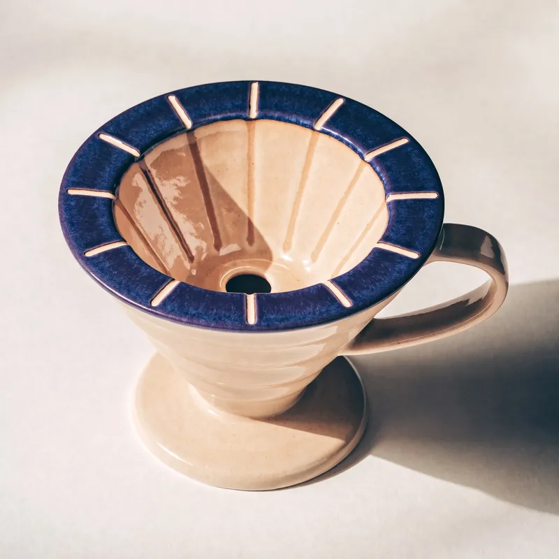 Concept ceramic pour-over dripper with an indigo rim and pale clay interior.