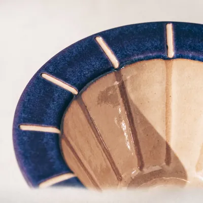 Concept dripper detail: deep indigo glaze and tick marks around the rim.